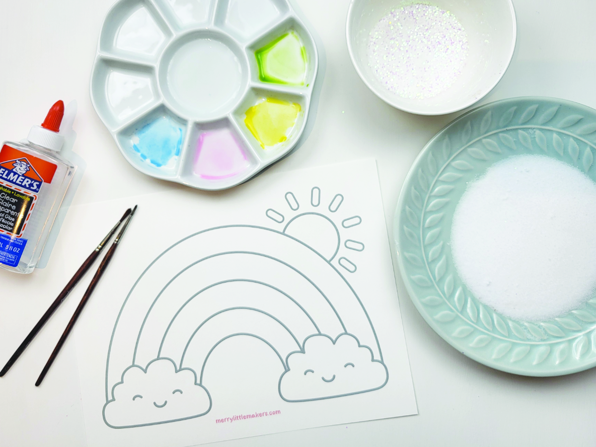 Supplies needed for making salt art pictures - watercolour paints, glue, a rainbow template, glitter and a plate of salt.