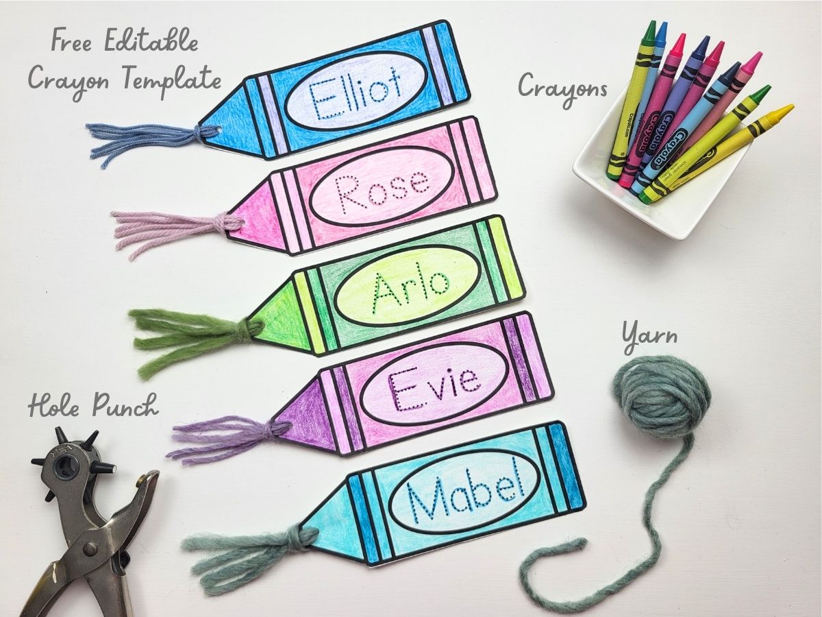 5 Colorful crayon bookmarks with craft supplies around them - scissors, yarn, hole punch, crayons. 